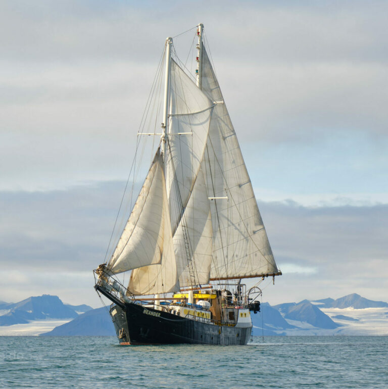 Segelschoner Meander unter vollen Segeln vor der Bergkulisse Spitzbergens