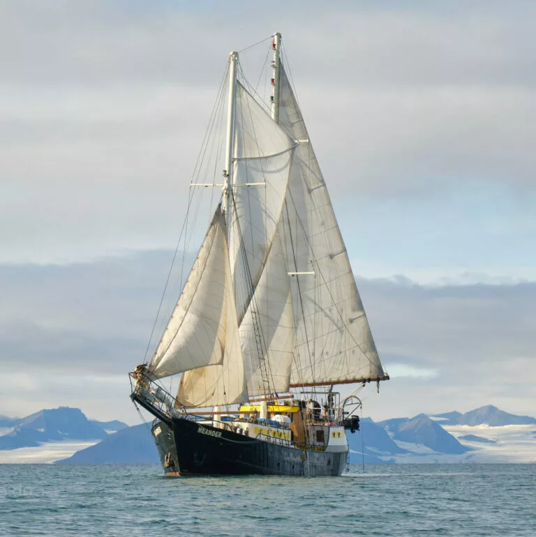 Segelschoner Meander unter vollen Segeln vor der Bergkulisse Spitzbergens