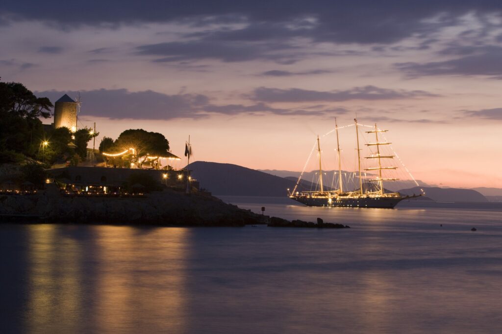 Großsegler von Star Clippers vor den Windmühlen von Mykonos in der Abenddämmerung