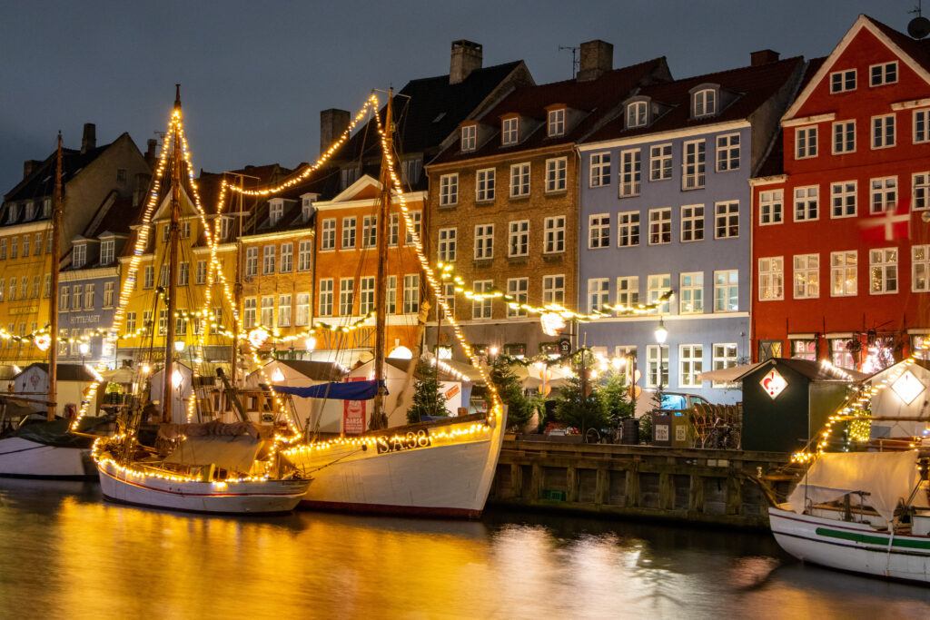 Nyhavn in Kopenhagen mit historischen Segelschiffen am Abend