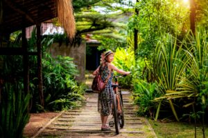 Asian lady rent a bicycle in tropical resort in Koh Mak
