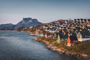 Nuuk capital of Greenland with Beautiful small colorful houses in myggedalen during Sunset Sunrise Midnight Sun. Sermitsiaq Mountain in Background. Blue and pink Sky.