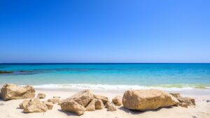 Türkisfarbener Strand mit hellen Felsen an der Ägäis