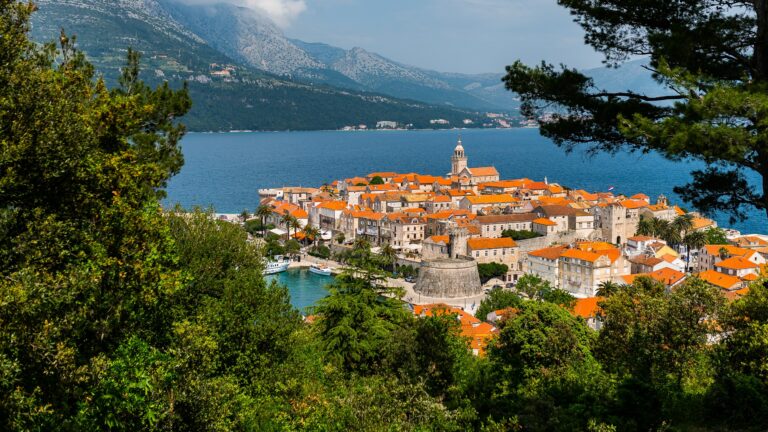 Blick auf die Altstadt von Korčula auf ihrer Halbinsel an der dalmatinischen Adria mit roten Ziegeldächern