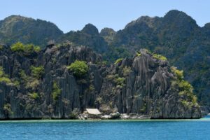 Coron auf Palawan - dramatische Kalksteinfelsen ueber tuerkisfarbenem Wasser im Siete Pecados Marine Park