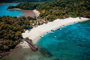 Golfito - tropischer Strand mit Booten und Regenwald am Golfo Dulce, Costa Rica