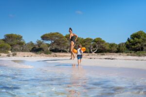 Mallorca - feiner weißer Sandstrand mit Pinien und türkisfarbenem Wasser an der Küste der Baleareninsel