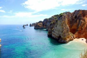Portimão an der Algarve - goldene Steilküste mit türkisfarbener Bucht und Segelbooten