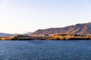 Reykjavík - Kuestenlandschaft mit dem Hausberg Esja im Abendlicht, Island