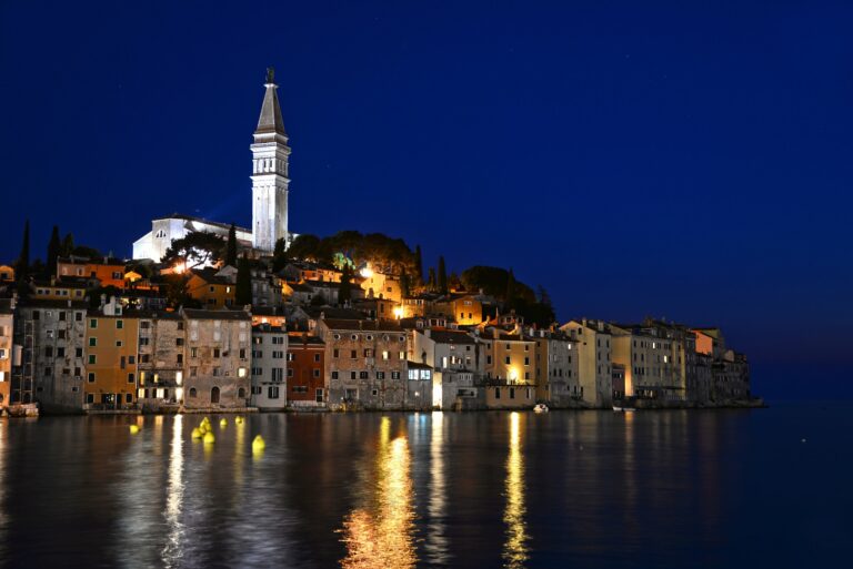 Altstadt von Rovinj in Istrien zur blauen Stunde, gespiegelt in der Adria mit dem Turm der Kirche St. Euphemia
